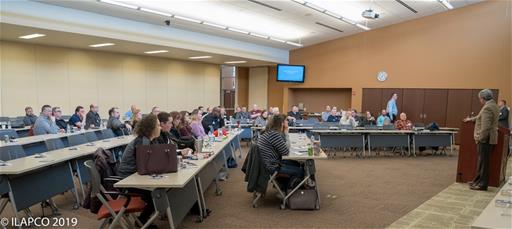 Attendees look up to the person speaking at the front